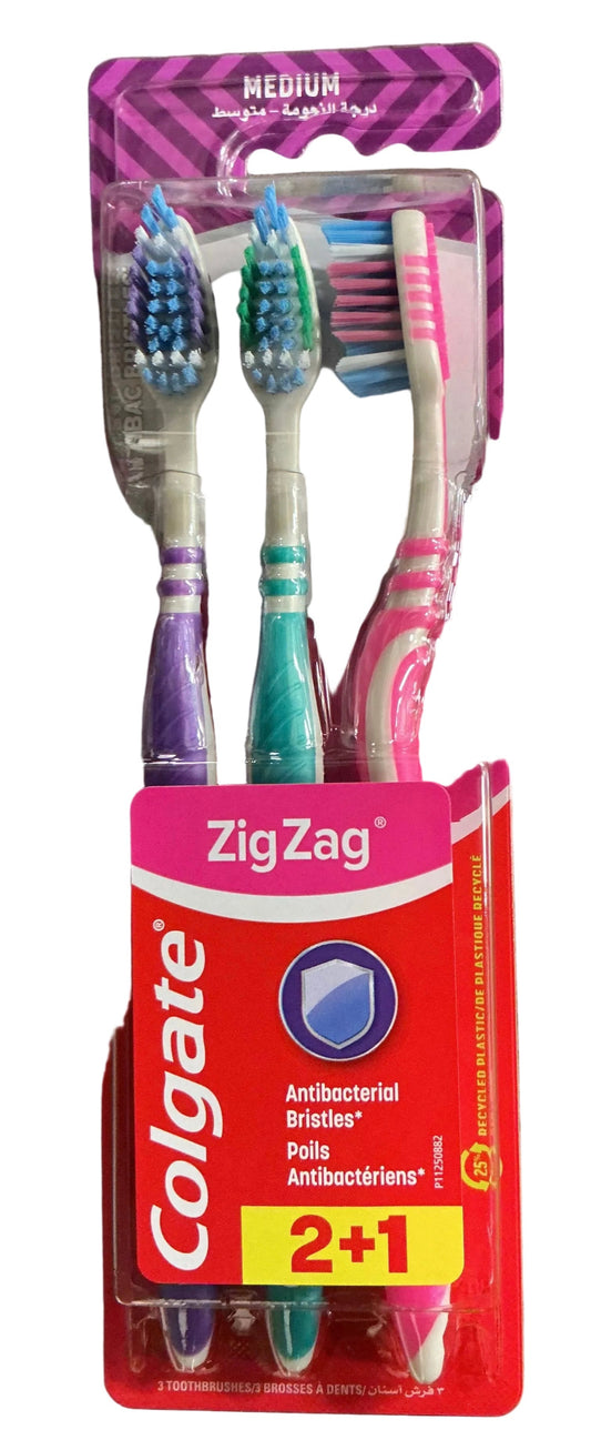A pack of three Colgate ZigZag toothbrushes in blister packaging, featuring purple, teal, and pink handles with blue, green, and pink bristles.